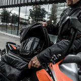 Motorcycle rider carrying helmet inside Kriega Max28 motorcycle backpack