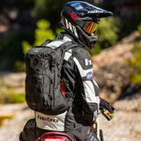 Rider sitting on motorcycle wearing black Kriega Trail18 motorcycle backpack
