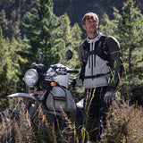 Adventure rider standing in forest wearing Kriega Trail18 motorcycle backpack