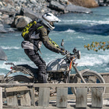 Adventure motorcycle rider crossing bridge wearing Kriega Trail18 motorcycle backpack